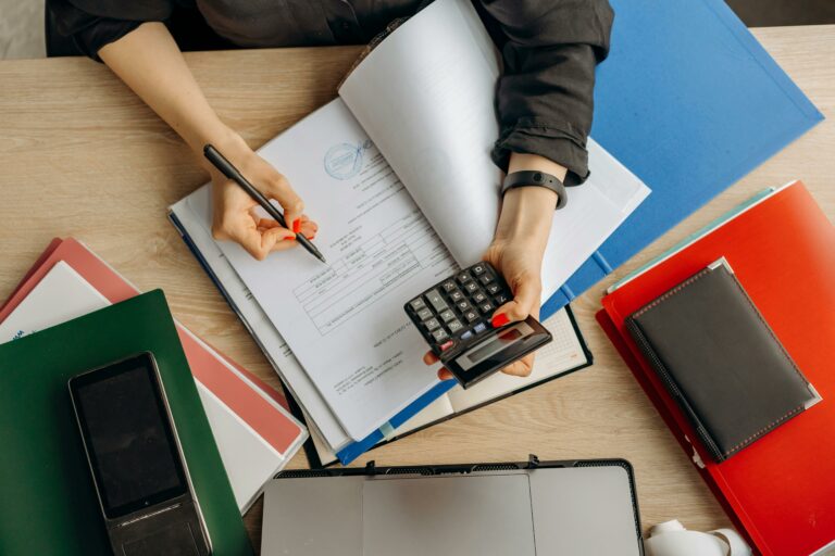 Documents, classeurs et calculatrice sur un bureau